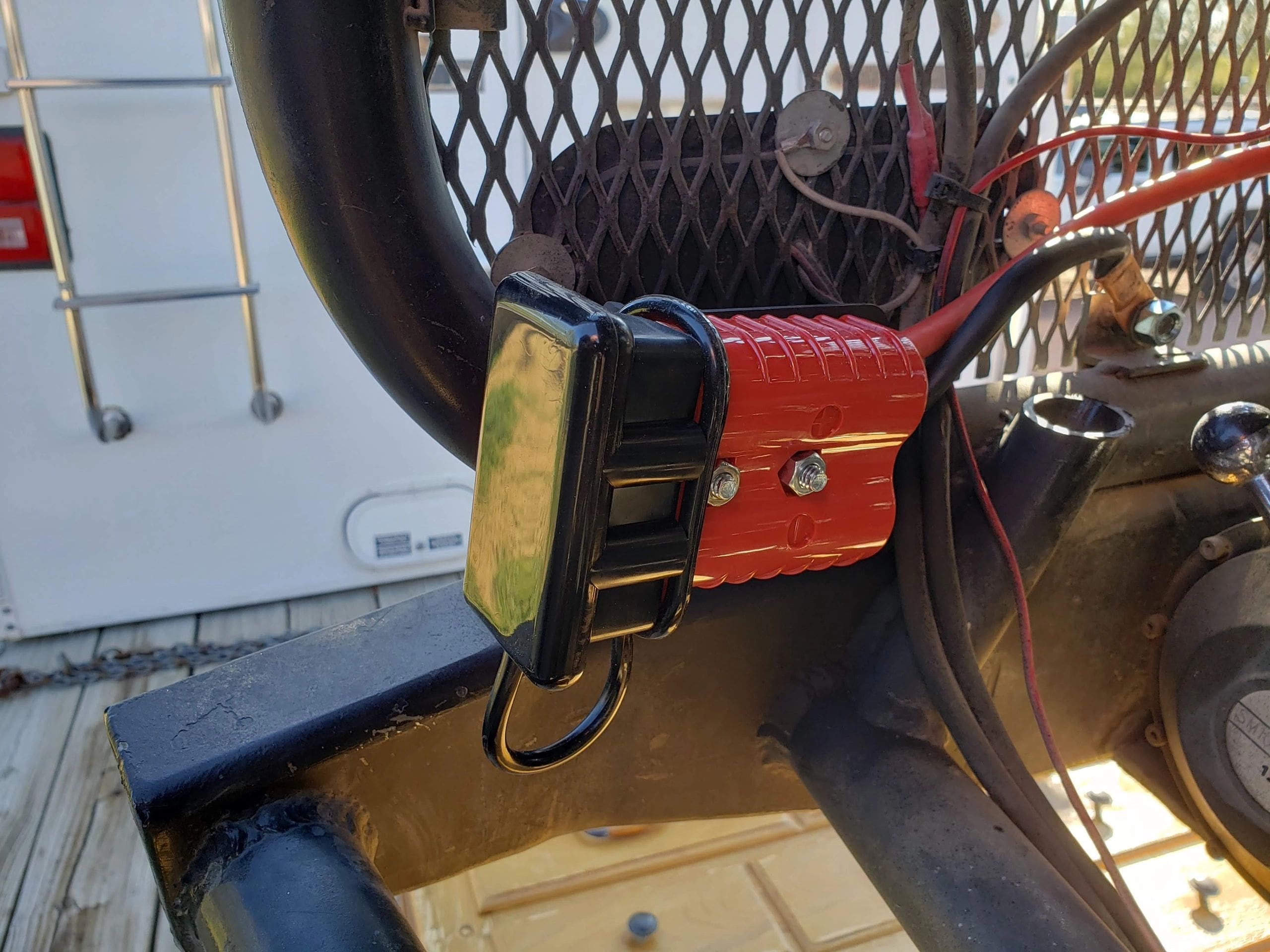 A red and black device hanging on the side of a fence.