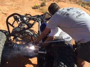 A man welding the front wheel of a motorcycle.