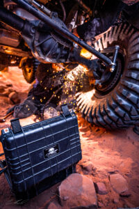 A person is welding in the dirt with an atv.