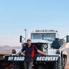 A man standing next to a large truck with the words " off road recovery ".