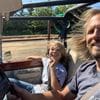 A man and girl in the back of a car.