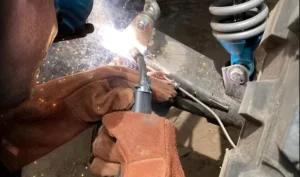 A person welding with an electric tool.